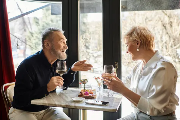 Um lindo casal compartilha risos e histórias sobre bebidas em um ambiente de restaurante encantador. — Fotografia de Stock