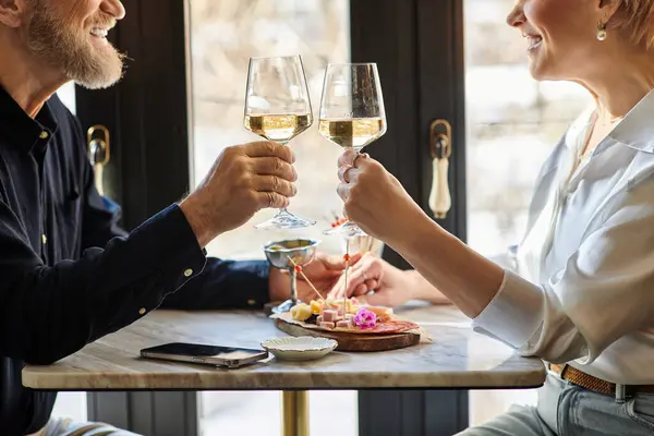 Um casal de meia-idade compartilha risos e bebidas espumantes, celebrando seu amor — Fotografia de Stock
