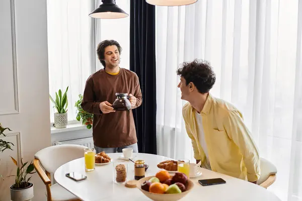 Gay couple enjoy a joyful morning together, sharing coffee and laughter in their stylish apartment. — Stock Photo