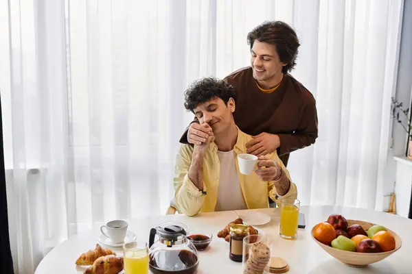 Two men share a warm breakfast moment filled with love and laughter in their stylish apartment. — Stock Photo