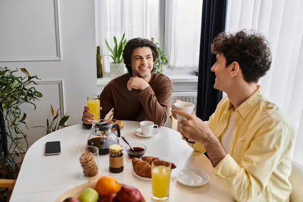 Two happy men enjoy breakfast together in a stylish apartment filled with warmth and love. — Stock Photo