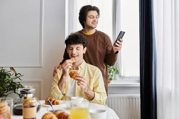 Gay couple shares a joyful morning with pastries in a stylish apartment. — Stock Photo