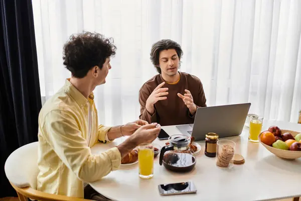 Two men share a loving moment at breakfast in their stylish apartment while discussing life. — Stock Photo