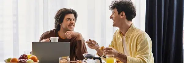 Two men share a joyful breakfast together in their modern apartment, enjoying each others company, banner — Stock Photo