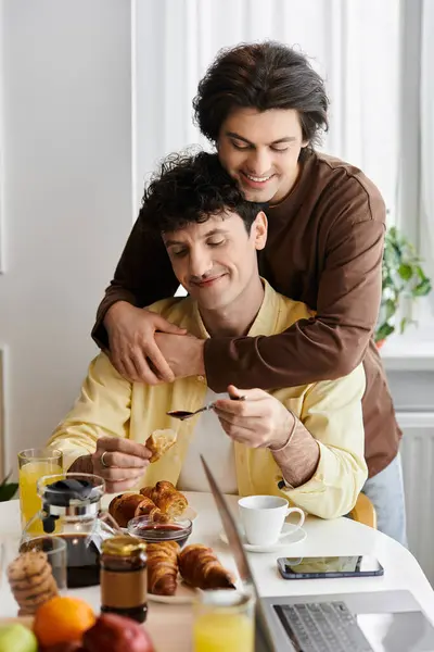 In a stylish apartment, a happy couple enjoys breakfast while embracing each other lovingly. — Stock Photo
