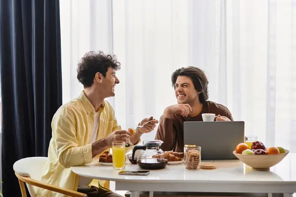 A joyful morning as a gay couple enjoys each others company over breakfast in their apartment. — Stock Photo