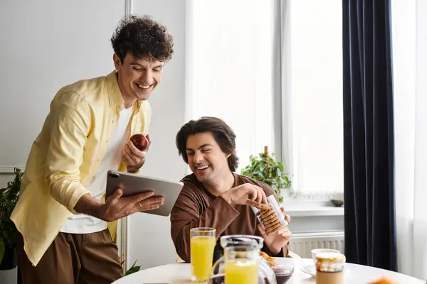 Two men share laughter and a meaningful moment while enjoying breakfast in their stylish apartment. — Stock Photo
