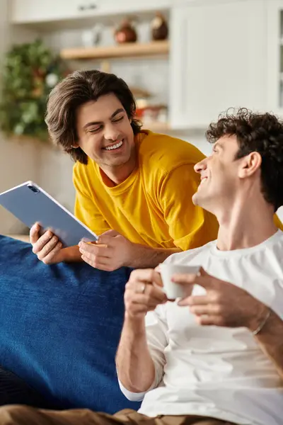 Two happy men enjoy a cozy afternoon together in their stylish apartment while sharing laughter. — Stock Photo
