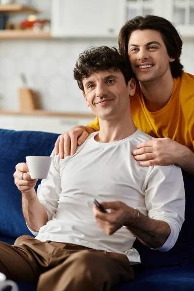 Una coppia gay felice gode della reciproca compagnia mentre si rilassa su un comodo divano. — Foto stock