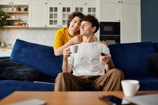Due uomini gay godono di tempo di qualità insieme, sorridendo e condividendo un drink nella loro accogliente casa. — Foto stock