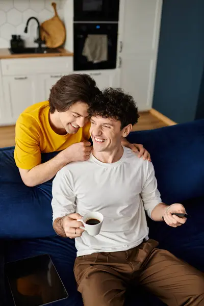 Due uomini gay condividono un momento gioioso in un accogliente appartamento moderno, sorridendo e ridendo insieme. — Foto stock