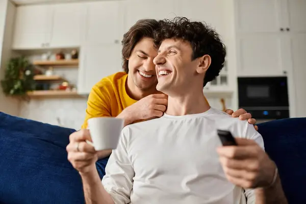 Due uomini gay condividono momenti gioiosi nel loro elegante appartamento, abbracciando amore e connessione. — Foto stock
