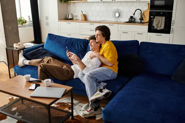 Two men share a warm moment together on a cozy couch, enjoying each other's company. — Stock Photo