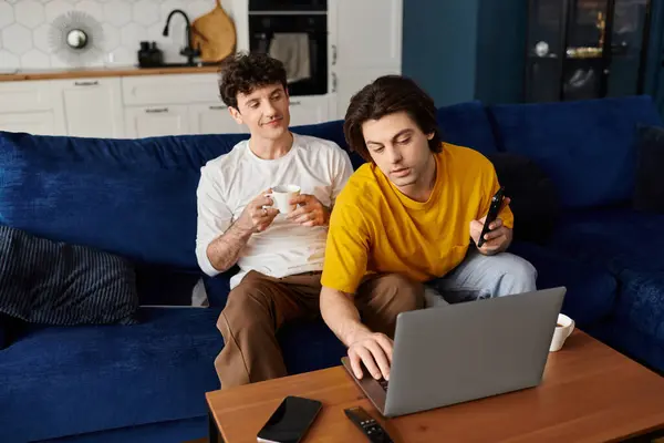 Due uomini si rilassano nel loro elegante appartamento mentre condividono un momento di cuore insieme. — Foto stock