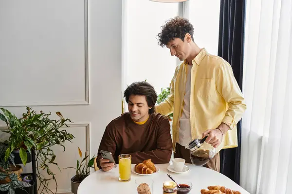 Two men share a joyful moment over brunch in their stylish apartment with a cozy ambiance. — Stock Photo
