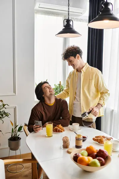 A gay couple shares a cozy breakfast, smiles, and affection in their stylish apartment. — Stock Photo