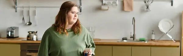 In a cozy kitchen, a young woman with Down syndrome radiates joy and confidence. — Stock Photo