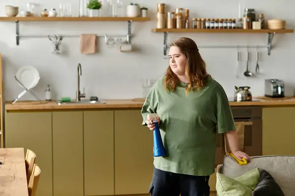 A young woman prepared to tidy her home, radiating confidence and comfort in her space. — Stock Photo
