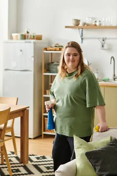 Espaço brilhante e acolhedor mostra uma jovem mulher com síndrome de Down confiantemente arrumando sua casa. — Fotografia de Stock