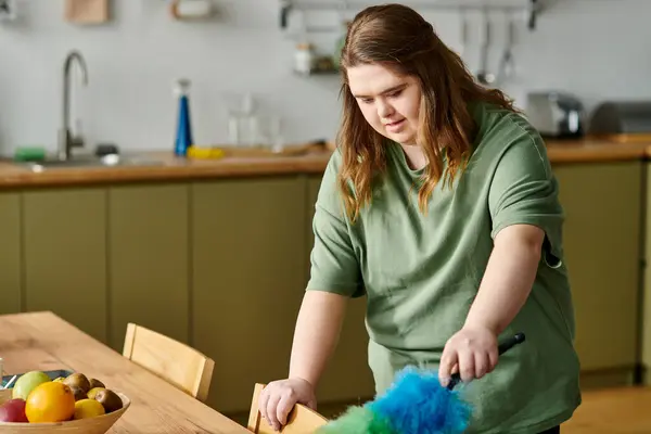 Pretty young woman with Down syndrome enjoys her time cleaning and organizing in a comfy kitchen. — Stock Photo