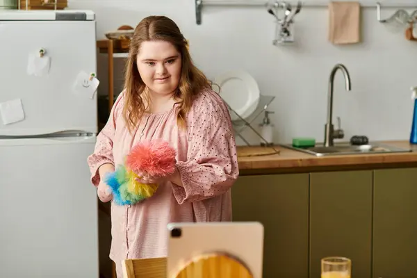 Young woman with Down syndrome smiles confidently at home, holding colorful fluffy props. — Stock Photo