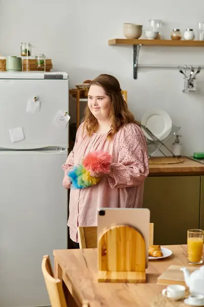 Pretty woman with Down syndrome enjoys her time cleaning and tidying her cheerful kitchen area. — Stock Photo