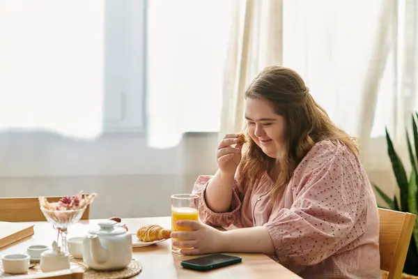 Young woman with Down syndrome appreciates a delightful breakfast while seated at home. — Stock Photo