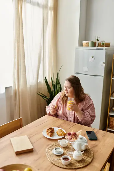 A young woman with Down syndrome smiles, enjoying a lovely breakfast at home. — Stock Photo