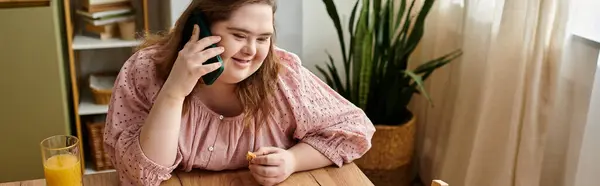 Una giovane donna con la sindrome di Down si rilassa a casa, sorridendo e parlando al telefono con eccitazione. — Foto stock