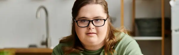 A young, pretty woman with Down syndrome displays confidence and joy in her cozy home environment. — Stock Photo