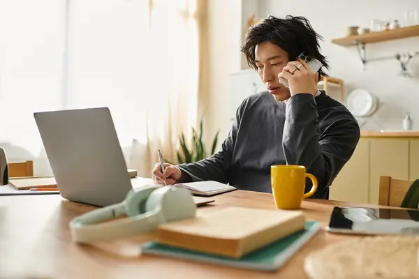 Молодой азиат учится дома, делая заметки и пользуясь ноутбуком. — Stock Photo