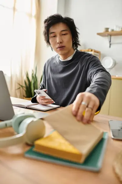 Focused young man engages in online learning at home, savoring a delicious snack during study time. — Stock Photo