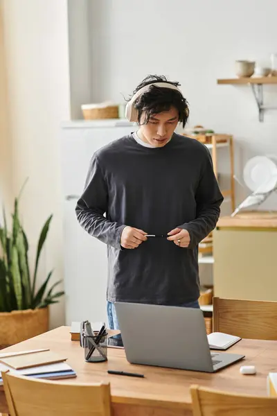 Handsome young man studies intently at his laptop while enjoying a calm home study space. — Stock Photo