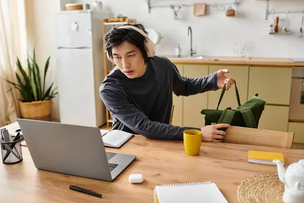 Guapo joven se centra en sus estudios en línea mientras se prepara para tomar notas. - foto de stock