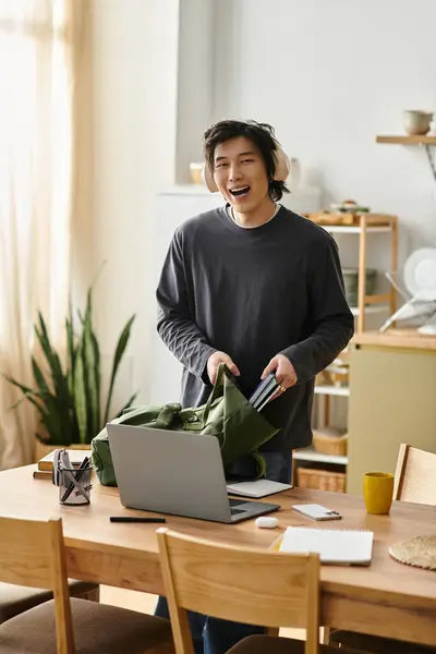 Young man engages with his laptop while preparing for online classes at home, showcasing focus. — Stock Photo