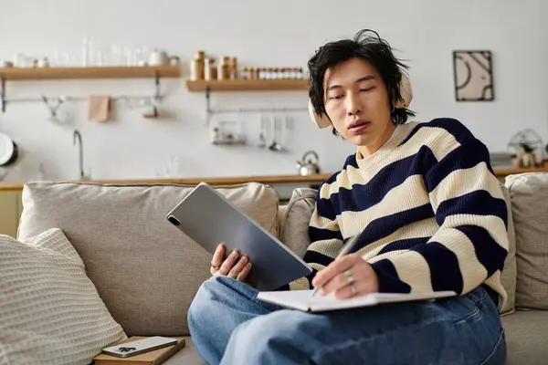 Handsome young man engages in online education while seated comfortably at home. — Stock Photo