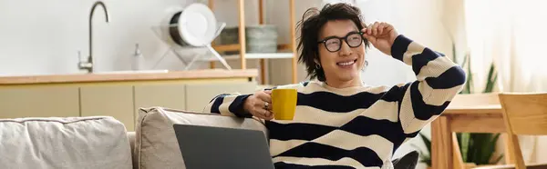 Un beau jeune homme asiatique étudie à la maison, s'engageant avec ses cours en ligne confortablement, bannière — Photo de stock
