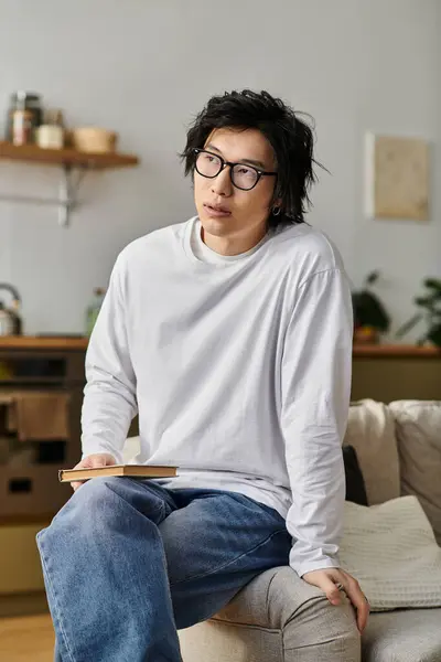 A handsome young man studies online from home, focused on his laptop and taking notes. — Stock Photo