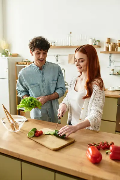 A loving couple enjoys quality time cooking fresh ingredients in their modern kitchen. — Stock Photo