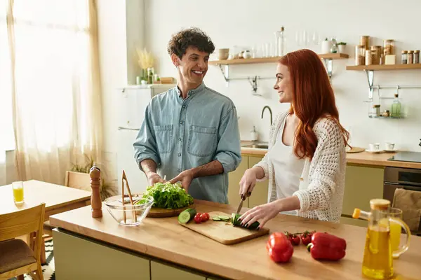 A young couple enjoys quality time shared in a bright kitchen, preparing a delicious meal together. — Stock Photo