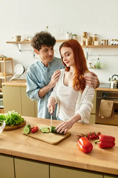 A young couple enjoys quality time in their cozy kitchen, cooking and laughing together. — Stock Photo