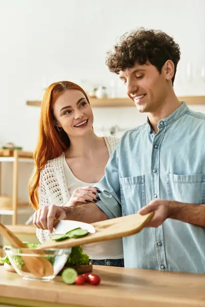 A young couple enjoys valuable time together as they chop fresh vegetables for a delightful meal. — Stock Photo