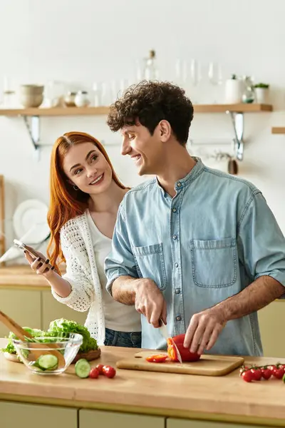 A young couple enjoys cooking together at home, sharing smiles and savoring every moment. — Stock Photo