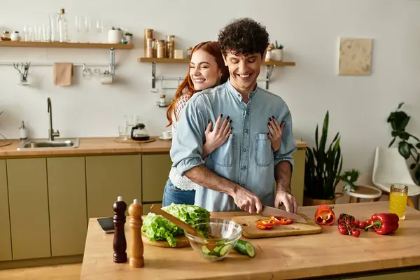Couple smiles and bonds while cooking together in their warm, welcoming kitchen. — Stock Photo