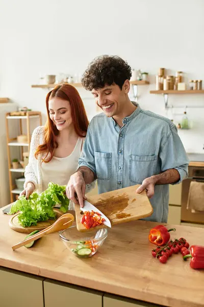Joyful couple engages in cooking activities, enjoying each others company in a warm kitchen. — Stock Photo