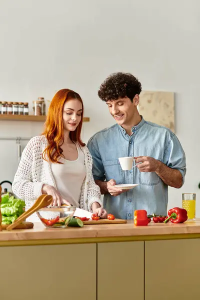A couple shares a joyful moment while cooking, creating a delicious meal filled with love. — Stock Photo
