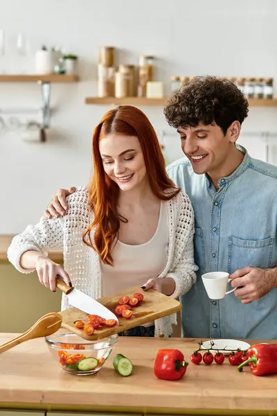 Couple enjoys each others company while preparing a fresh and delicious meal at home. — Stock Photo