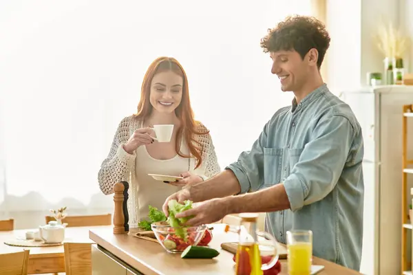 Couple enjoys cooking together in a bright kitchen, sharing joyful moments and connection. — Stock Photo