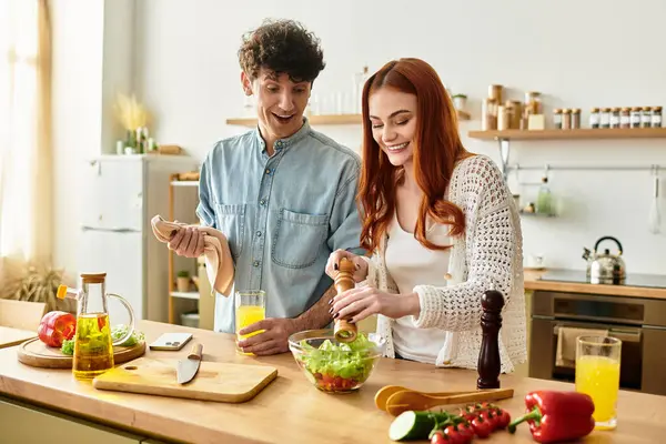 A couple happily prepares a fresh salad in their warm kitchen, savoring quality time together. — Stock Photo