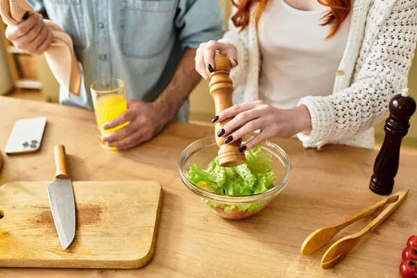 In a warm kitchen, a couple shares joyful moments as they prepare a delicious salad together. — Stock Photo